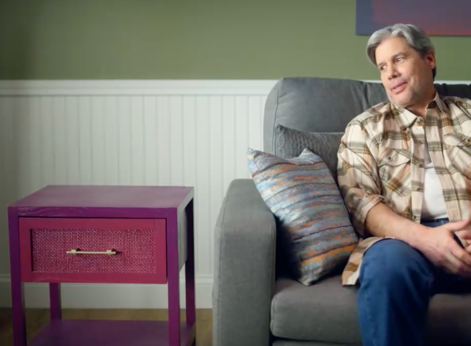 guy sitting next to purple coffee table